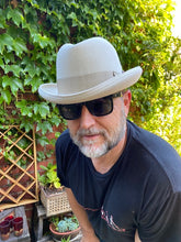 Load image into Gallery viewer, Carlisle Hats Johnny Royale Homburg in stone color, featuring a classic fedora style with a wide brim and elegant design.